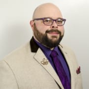 A person is wearing a suit and glasses.